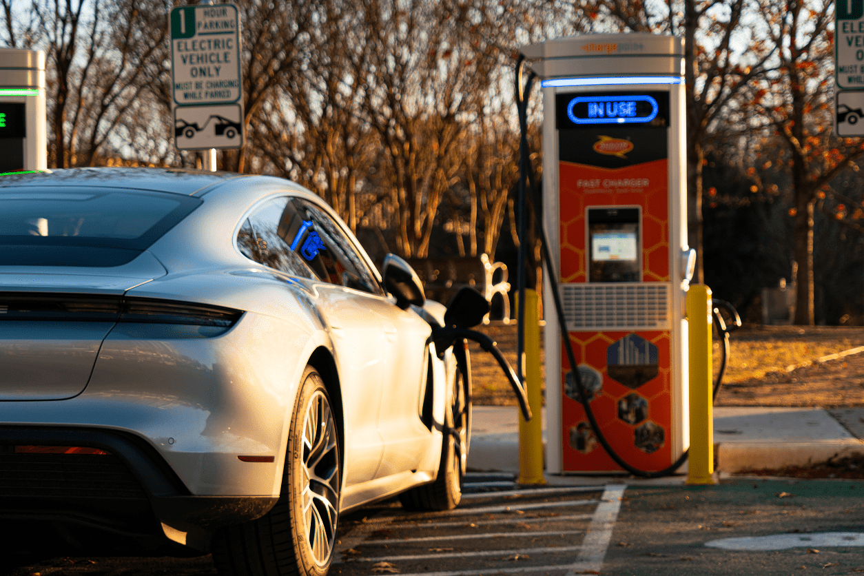 A white car is parked at the gas pump.