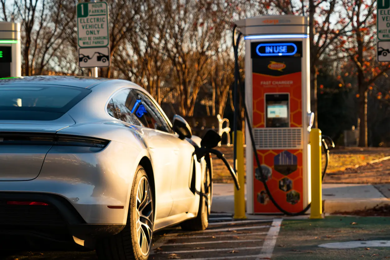 A white car is parked at the gas pump.