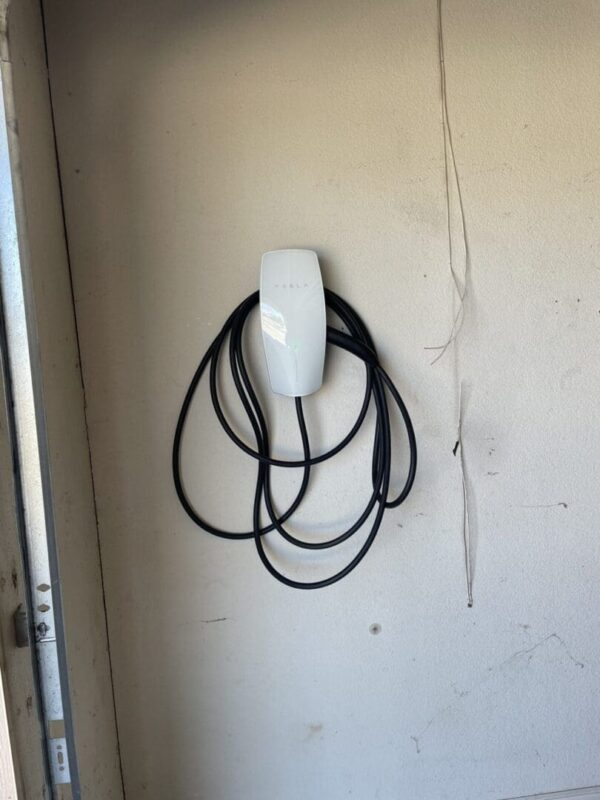 Tesla electric car charger on wall.